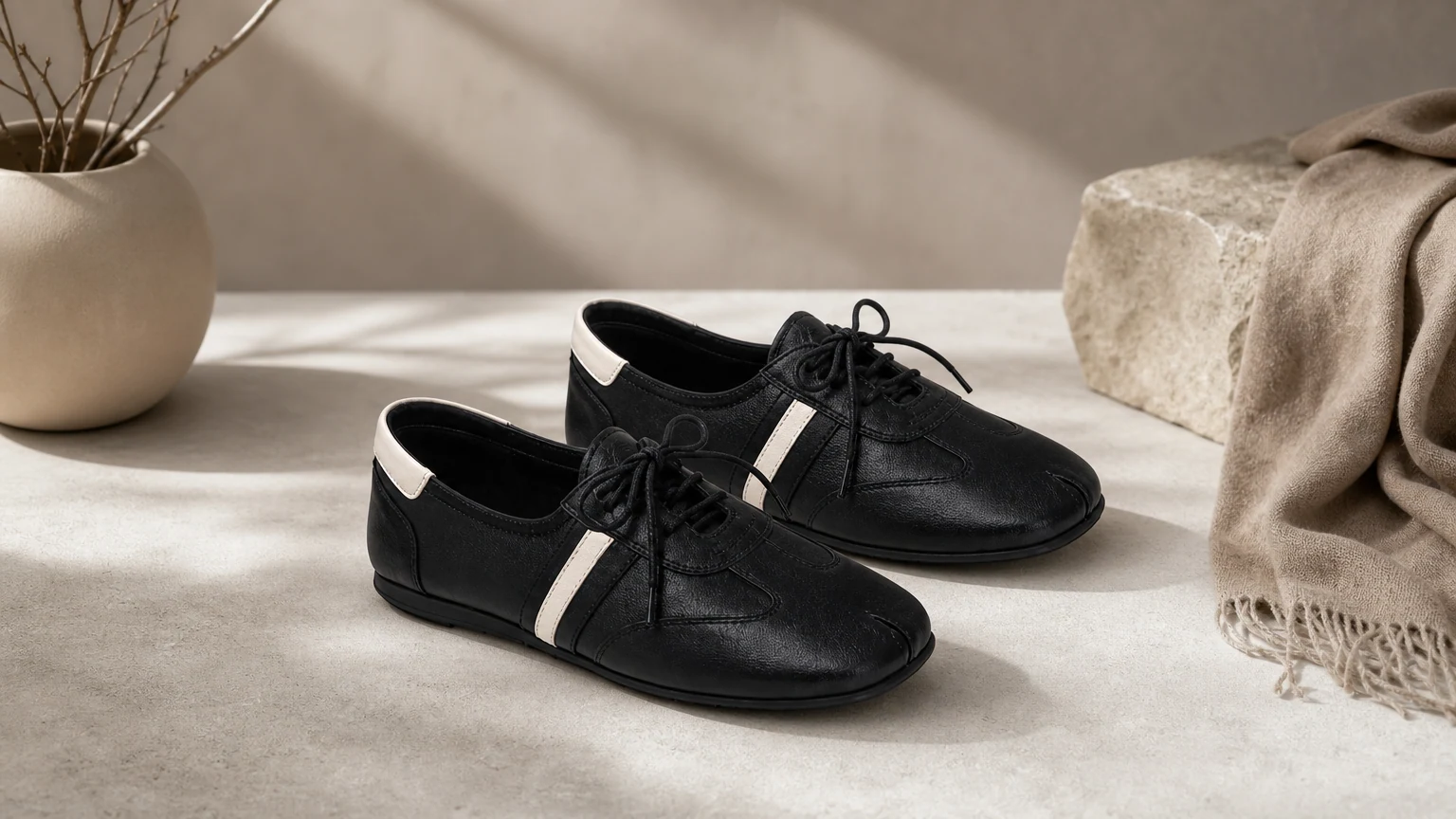 Schwarze sportliche Komfort-Loafer zum Schnüren mit quadratischer Zehenpartie, dargestellt in einer horizontalen Lifestyle-Szene