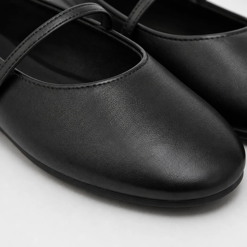 Close-up detail of the black Mary Jane flat material and strap construction