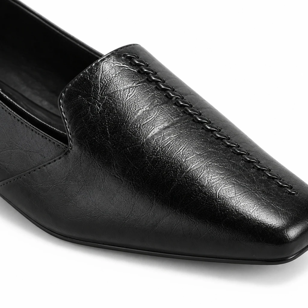 Detalle en primer plano del material y las costuras del mocasín con apariencia de cuero brillante