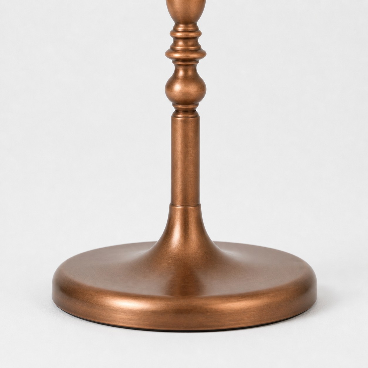 Close-up of round weighted base with layered wood-tone finish